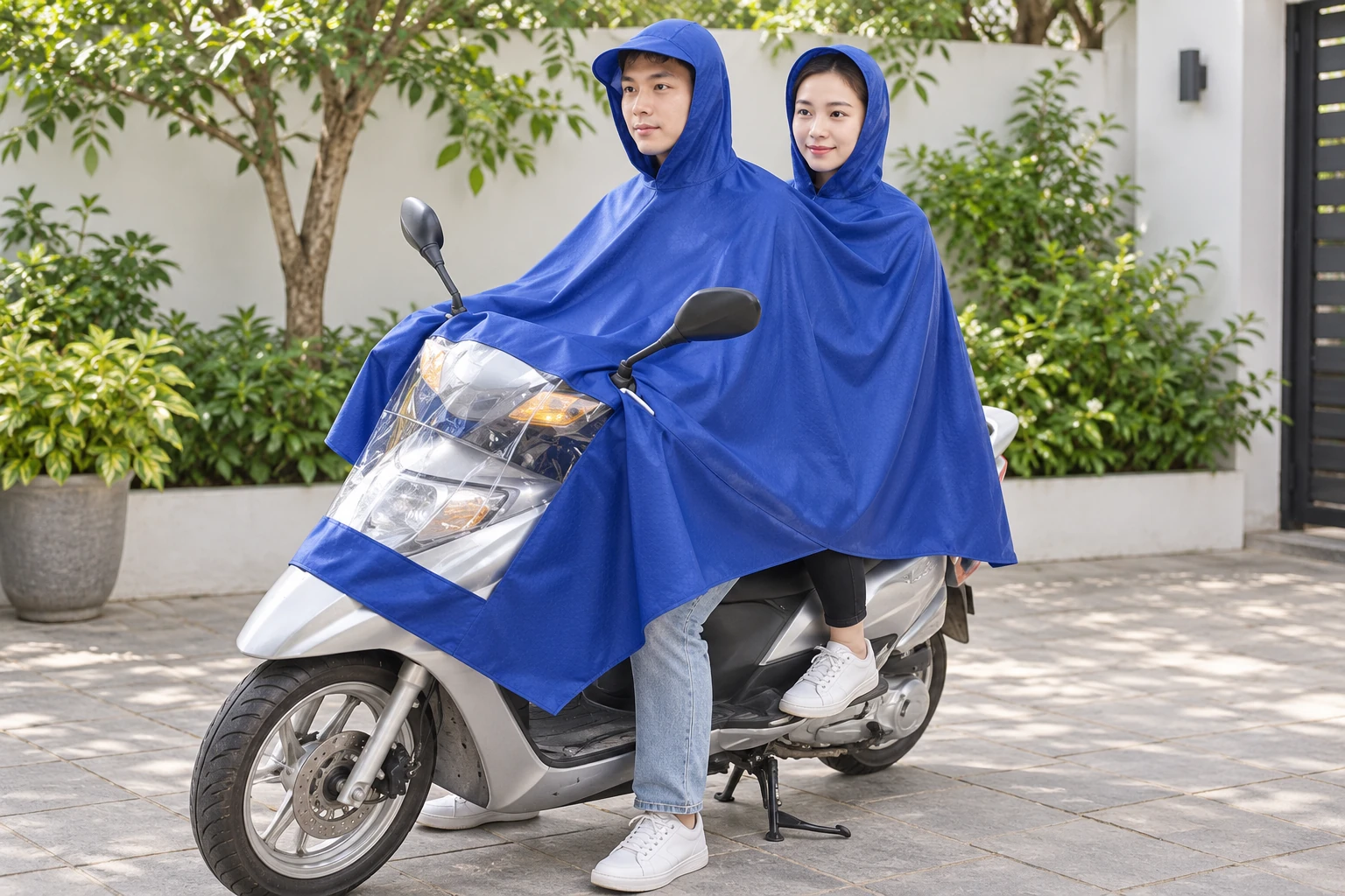 Hai người xem cách mặc áo mưa hai đầu trên xe đang đỗ trong sân
