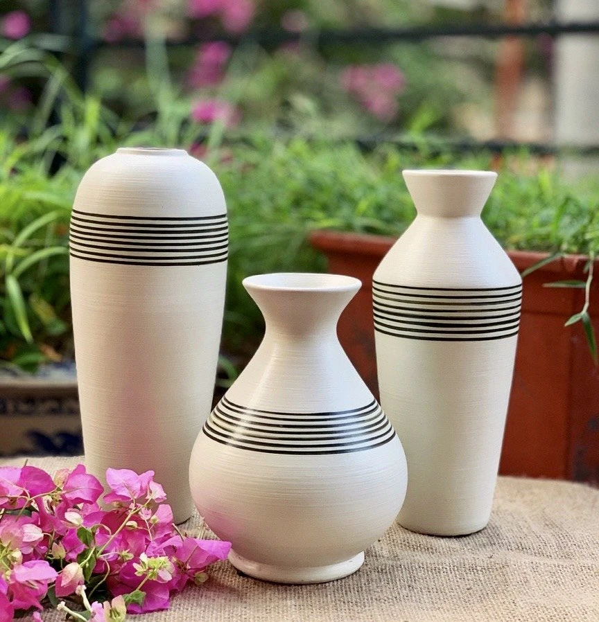 Ba lọ men xước kem sọc đen đặt cạnh hoa giấy