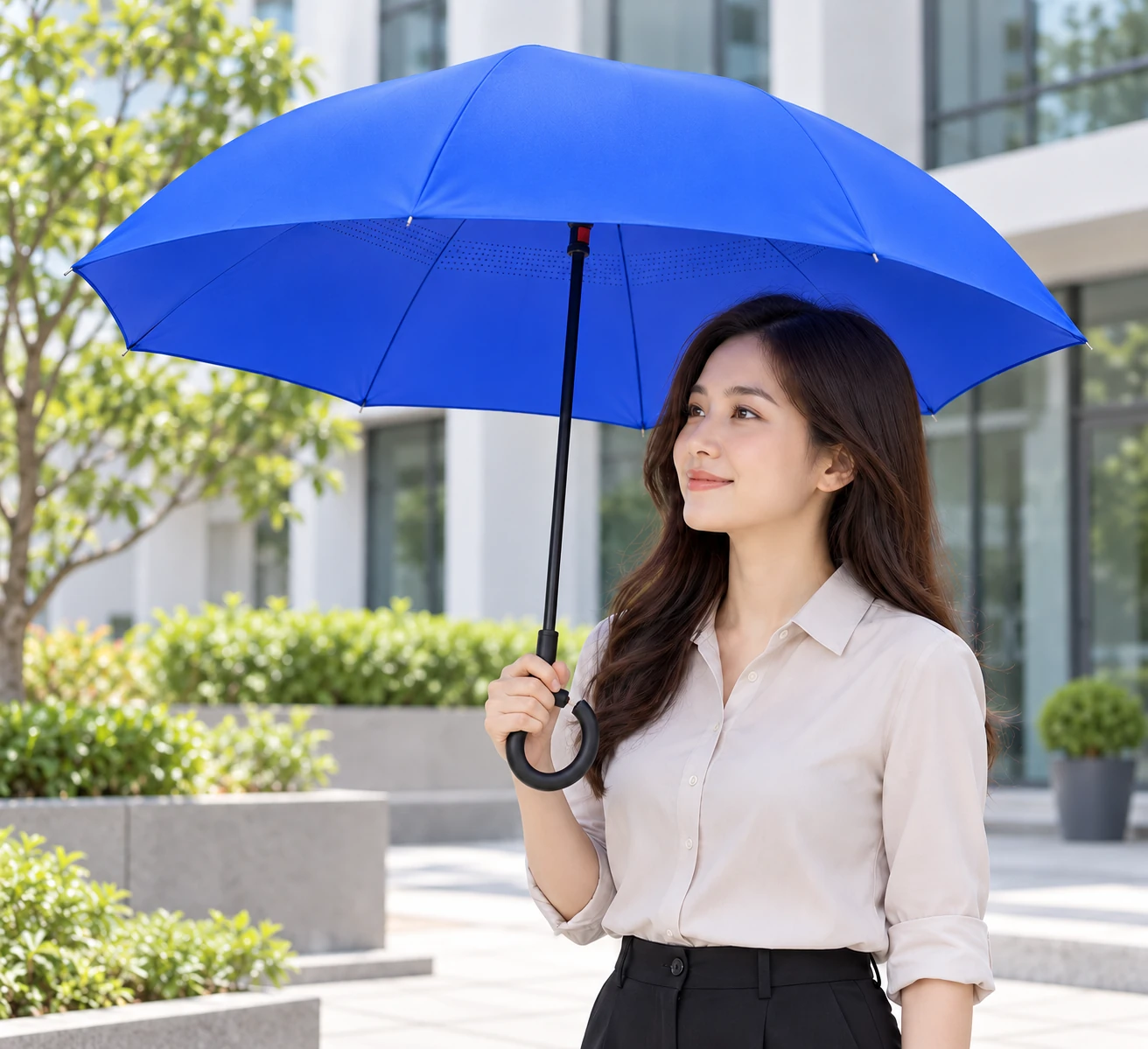 Người đi làm cầm dù xanh đã mở trong sân khô