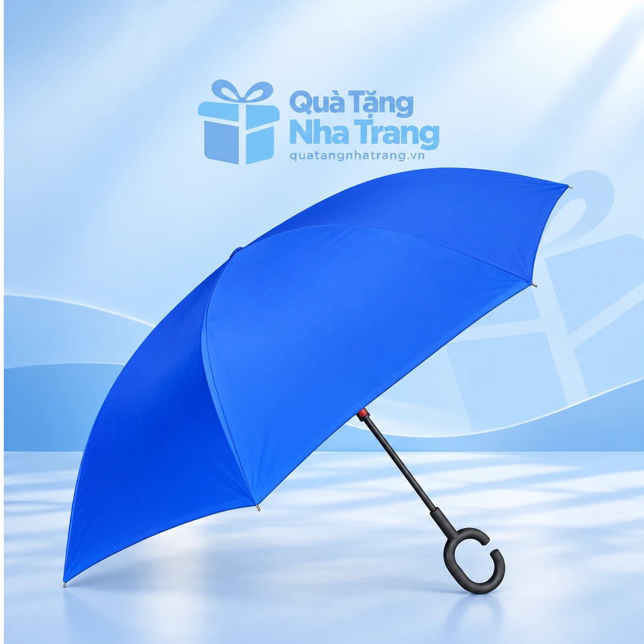 Dù gấp ngược xanh tay cầm chữ C trên nền Quà Tặng Nha Trang